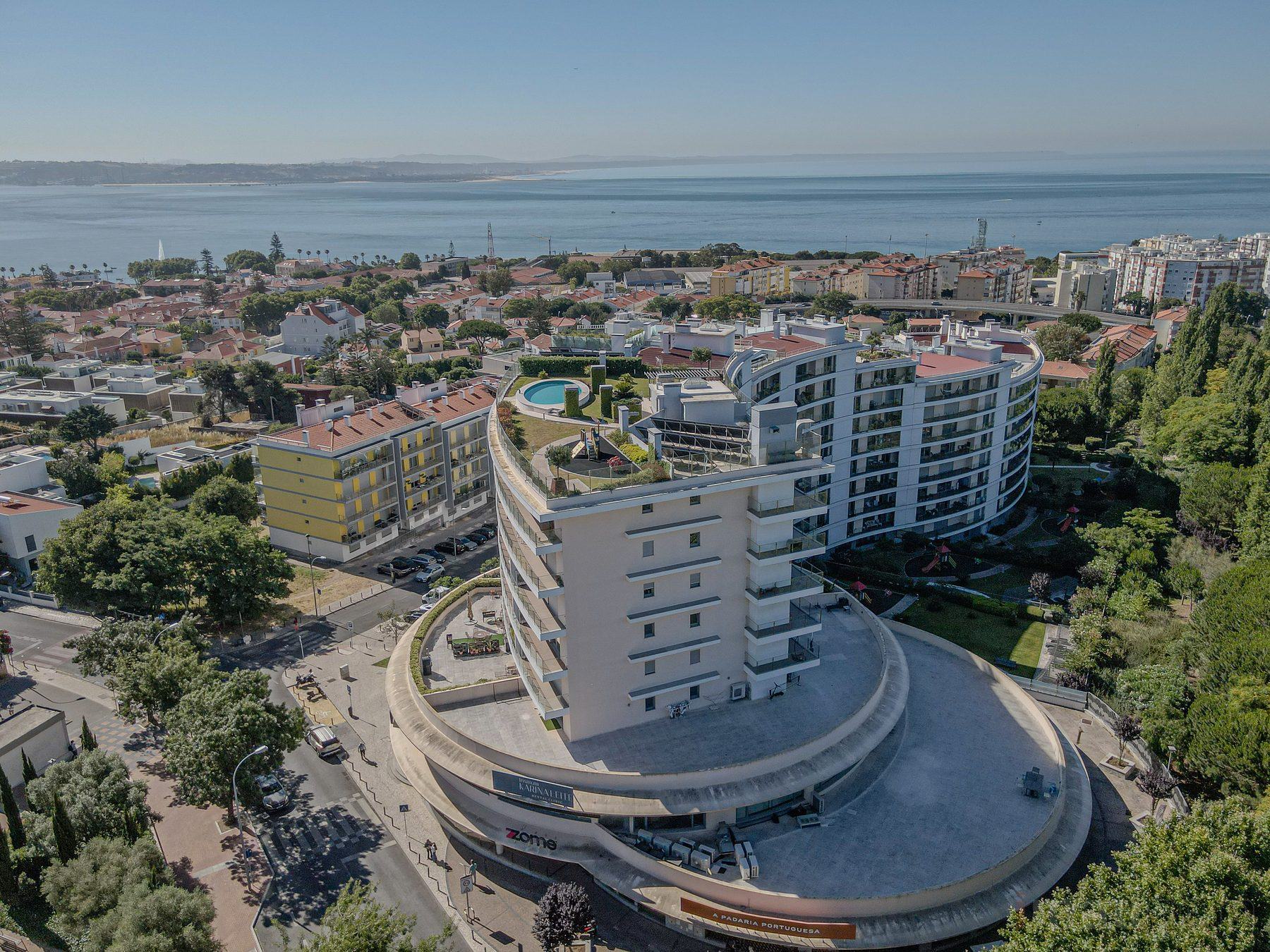 Fotografia imobiliária — vista aérea do edifício em Oeiras com o Tejo ao fundo
